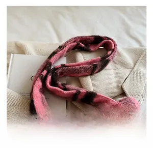 Close-up of pink and black checkered knit tote bag with thick plush handles