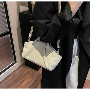 Detail of off-white pleated PU leather crossbody bag with silver hardware and soft texture