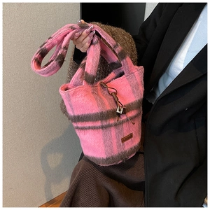 Detailed close-up of pink and brown checkered plush bucket bag with fuzzy texture