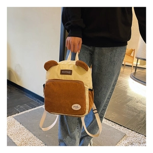 Detail of a corduroy backpack with cute bear ears and contrast brown front pocket