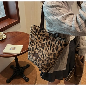 Detailed view of the plush leopard print tote bag with soft faux fur and leather patch