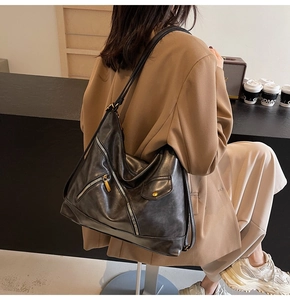 Detailed view of black PU tote bag with multiple zippers and pockets for commuting