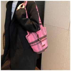 Detail of pink plaid tweed tote bag showing thick texture and metal bell pendant