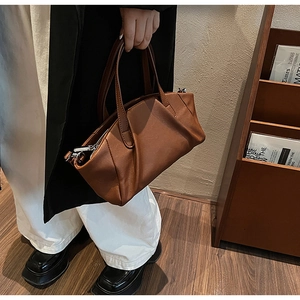 Detailed view of brown PU leather shoulder bag with textured pleats and metal zipper