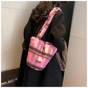 Detail of pink plaid wool tote bag showing texture and branded rectangular patch