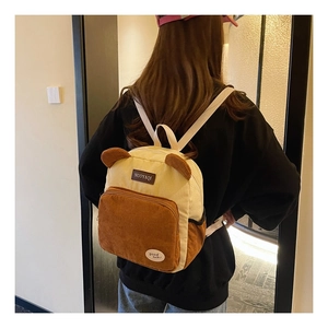 Detail of corduroy backpack with 3D bear ears and cream-brown patchwork texture