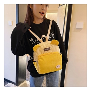 Close-up of yellow corduroy backpack with cute bear ears and stylish texture