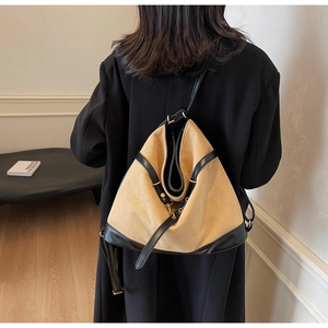 Details der minimalistischen beigen Canvas-Tasche mit schwarzem Lederbesatz und Goldhaken