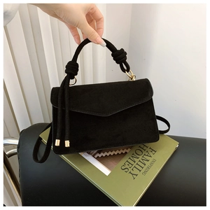 Minimalist black suede rectangular handbag with unique braided knot handle and gold hardware