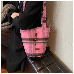 Detail of plush plaid tote bag showing soft pink check fabric and embossed leather tag
