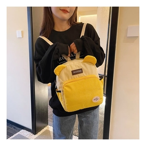 Close-up of yellow corduroy backpack featuring cute animal ears and high-quality texture