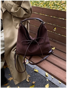 Close-up of a large dark brown matte PU leather tote bag with stylish bow decoration