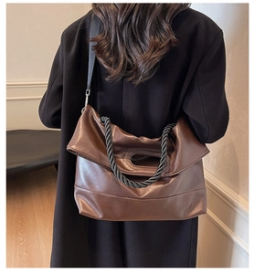 Detail of soft PU leather tote bag with unique black spiral woven handle and shoulder strap