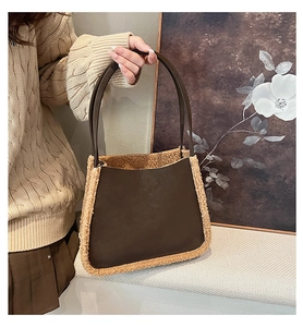 Detail of dark brown faux leather tote with cream faux shearling trim and dual handles