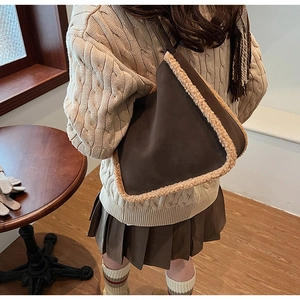 Detail of a brown faux suede tote bag with lamb wool trim worn with a warm autumn outfit
