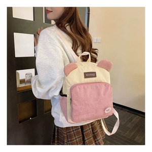 Detail of pink and beige corduroy backpack with cute bear ears and small badges