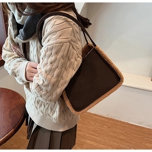 Close-up of brown suede tote bag with beige shearling trim and slim shoulder strap