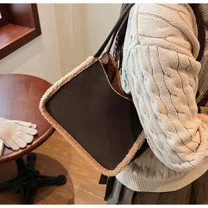 Detail shot of brown faux suede tote bag with beige plush fleece trim on shoulder