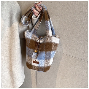 Close-up of the blue and brown plaid plush fabric texture with drawstring and amber bead