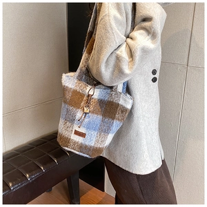 Detail of the blue and brown checkered plush tote bag with drawstring and brand tag