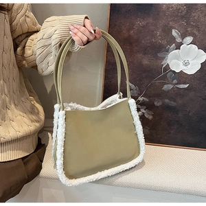 Close-up of olive green matte leather tote bag with white faux shearling trim on sweater