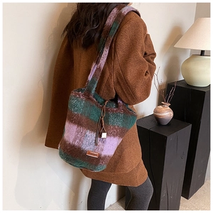 Detailed close-up of plaid faux fur tote bag with green and purple patchwork pattern