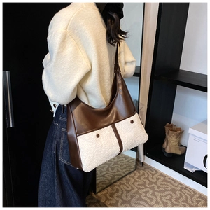Detail of hobo bag featuring dark brown faux leather and white sherpa patchwork pockets