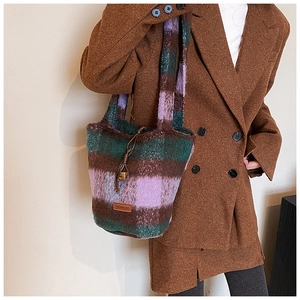 Detailed close-up of retro plaid plush tote bag texture with premium leather logo tag