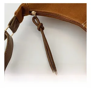 Detail shot of smooth metal zipper and textured canvas fabric on a brown tote bag