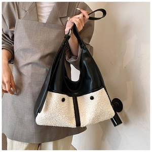 Detail of the chic tote bag featuring black leather and white faux shearling patchwork design