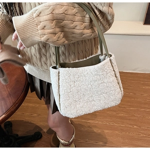 Detailed texture of white plush faux shearling tote with green leather strap details