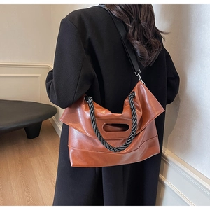 Brown faux leather crossbody bag with braided rope handle and wide shoulder strap