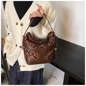 Detail of vintage hobo bag featuring leopard print texture and brown leather tassels