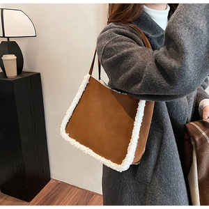 Detailed side view of brown faux suede tote bag with white plush trim on model