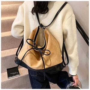 Detail of vintage khaki frosted PU leather bucket bag with black ribbon bow decoration