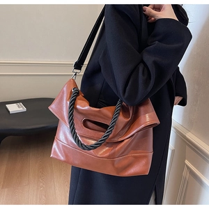 Detail of soft brown PU leather tote bag with unique black woven rope handle and wide strap