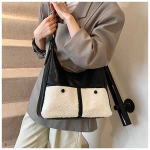 Detail of black leather and white shearling tote bag with decorative buttoned pockets