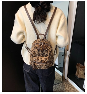 Modèle portant un mini sac à dos en peluche léopard avec des bretelles en cuir marron