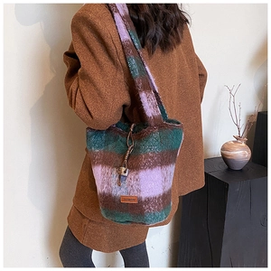 Close-up of wool plaid bucket bag with purple and green pattern and drawstring closure