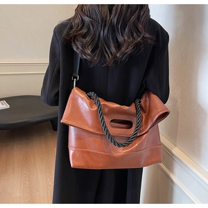 Detail of caramel orange faux leather tote bag with braided rope handle and shoulder strap