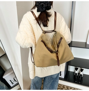 Rückansicht der Khaki-Nylon-Pendeltasche mit braunen Lederriemen an einem Modell