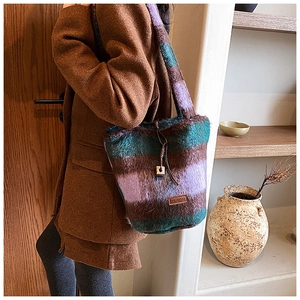Detail of colorful striped plush tote bag with leather logo tag and drawstring detail