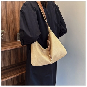 Large beige PU tote bag with brown leather straps and knot charm detail on model