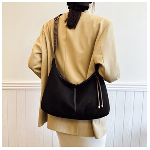 Detail of vintage black hobo bag with white contrast stitching and brown leather strap