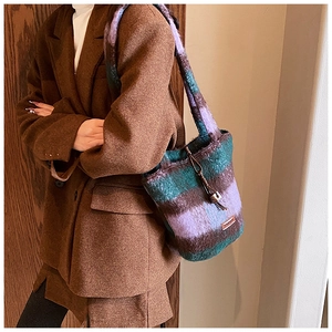Detail of plush tote bag showing striped faux fur texture and brand leather patch