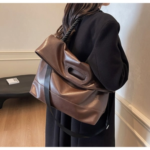 Detail of soft dark brown PU leather tote bag showing crossbody strap and foldover top