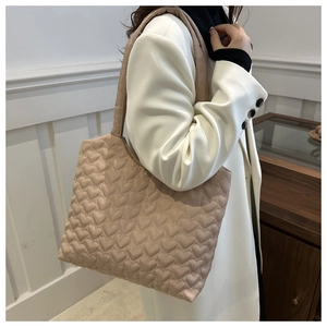 Détail du sac cabas matelassé beige avec un motif de texture gaufré en forme de cœur 3D