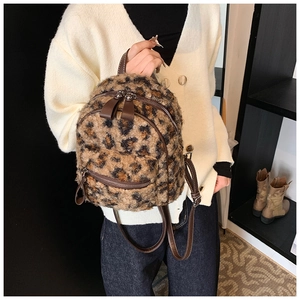 Détail du tissu en peluche léopard et de la fermeture éclair sur un mini sac à dos
