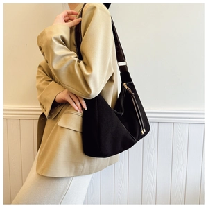 Close-up of black PU leather hobo tote bag with brown shoulder strap and golden zipper detail