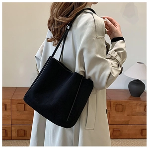 Vue latérale d'un grand sac cabas noir mat en simili cuir porté par un mannequin